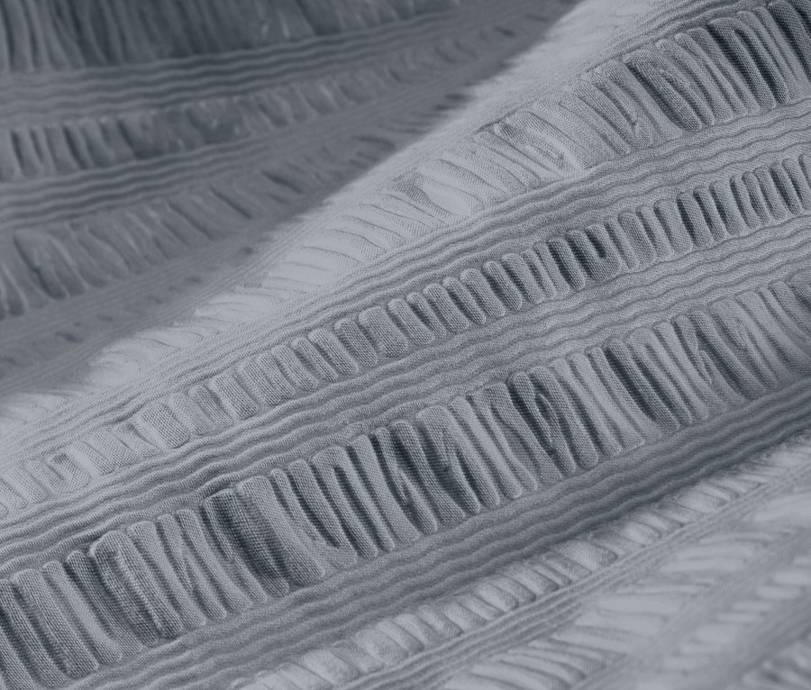 Nahaufnahme von grauer Seersucker-Bettwäsche in Normalgröße und Übergröße.