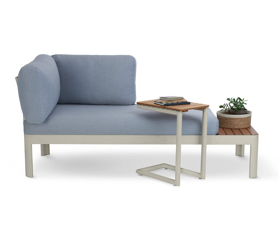 Blaues Sofa mit C-Table »Liska«, auf dem Bücher liegen, und daneben eine Pflanze.