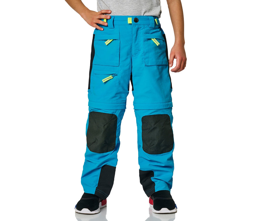 Junge trägt blaue Jako-O Zipp off Hose mit schwarzen Knieflicken.