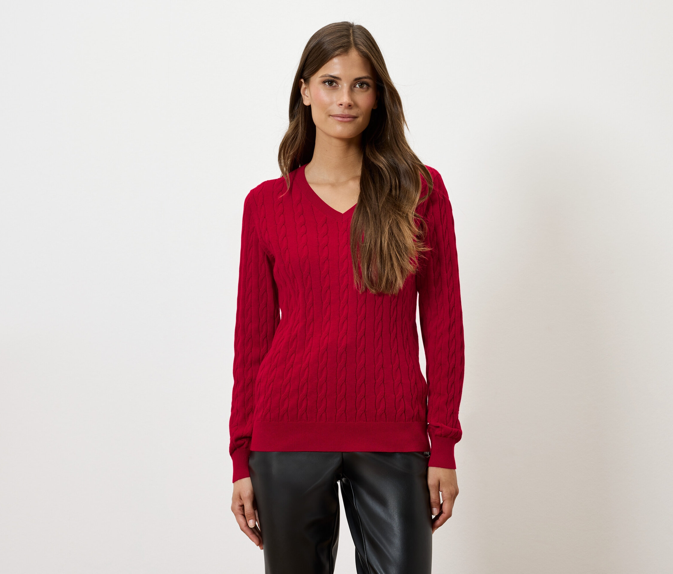 Frau trägt roten Pullover und schwarze Hose.
