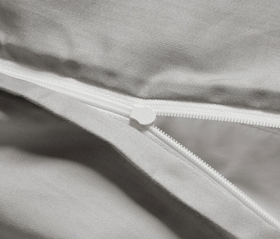 Detailaufnahme eines grauen Bettbezugs mit Reißverschluss.