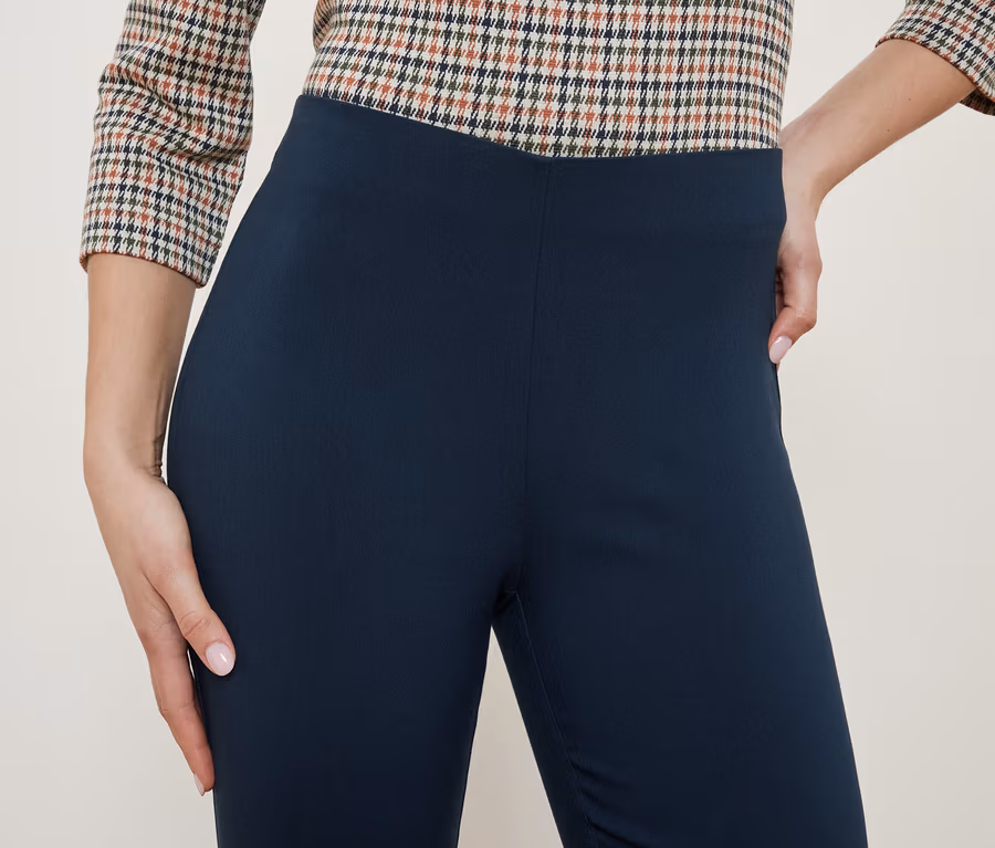 Oberteil eines Damenoutfits mit karierter Bluse und dunkelblauen Leggings.