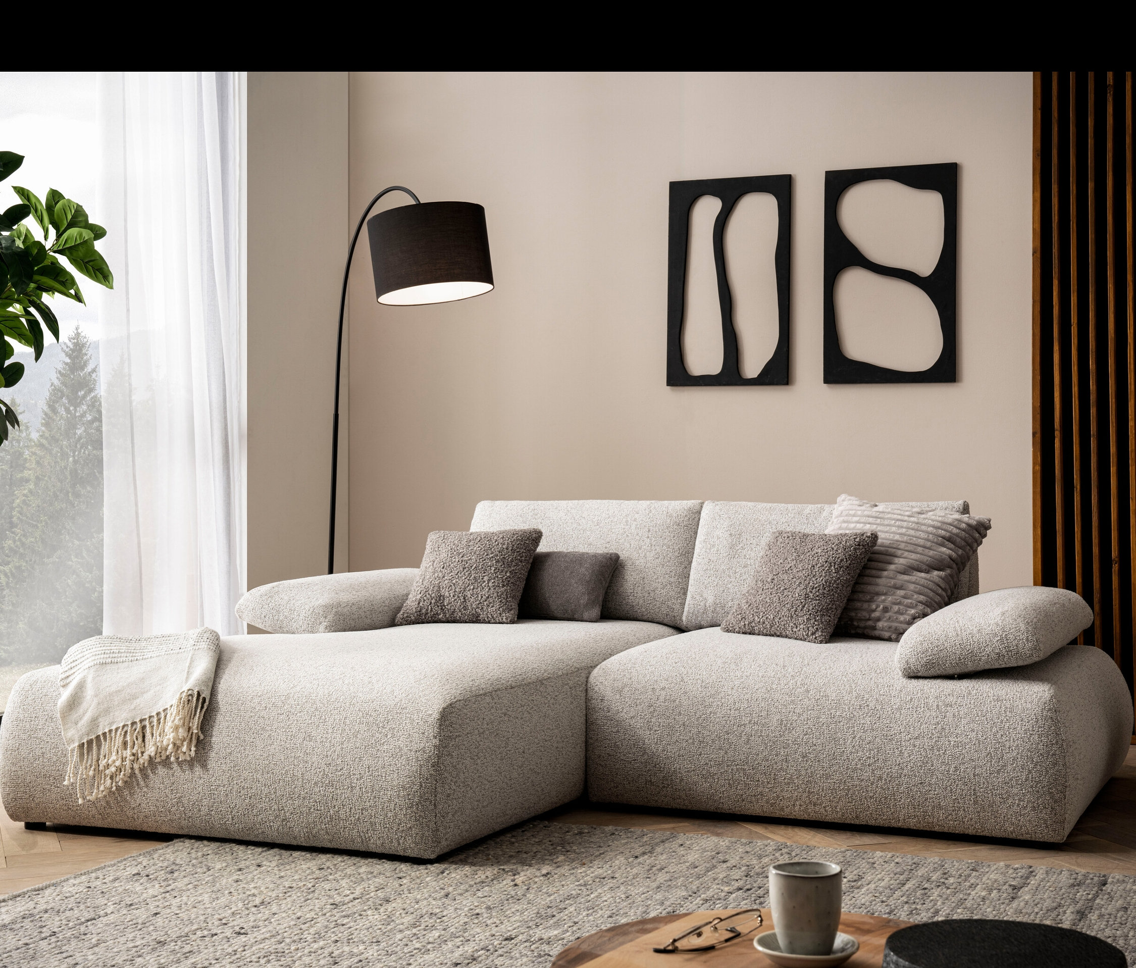 DOMO Ecksofa »Bela«, links, mit Armlehne in einem Wohnzimmer.