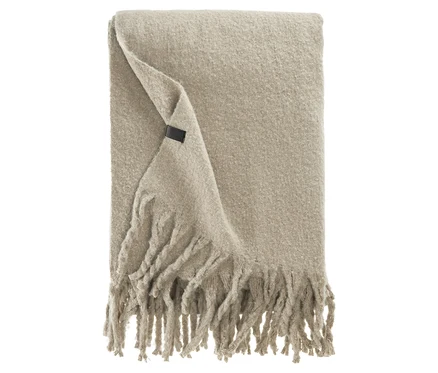Beige Decke mit Fransen und Etikett.