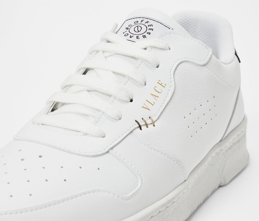 Detailaufnahme eines weißen Tchibo x VLACE Coffee Lover Sneakers.