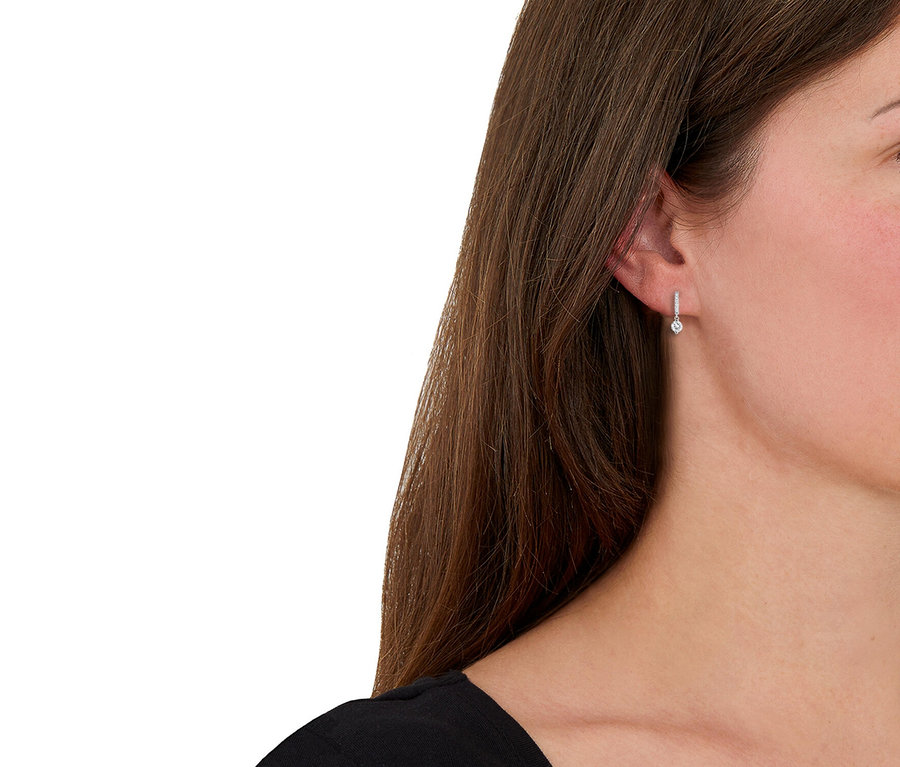Frau trägt Amor Ohrschmuck mit Herz-Motiv.
