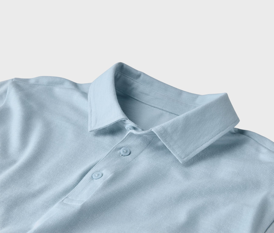 Nahaufnahme eines hellblauen Poloshirts mit Kragen und zwei Knöpfen.