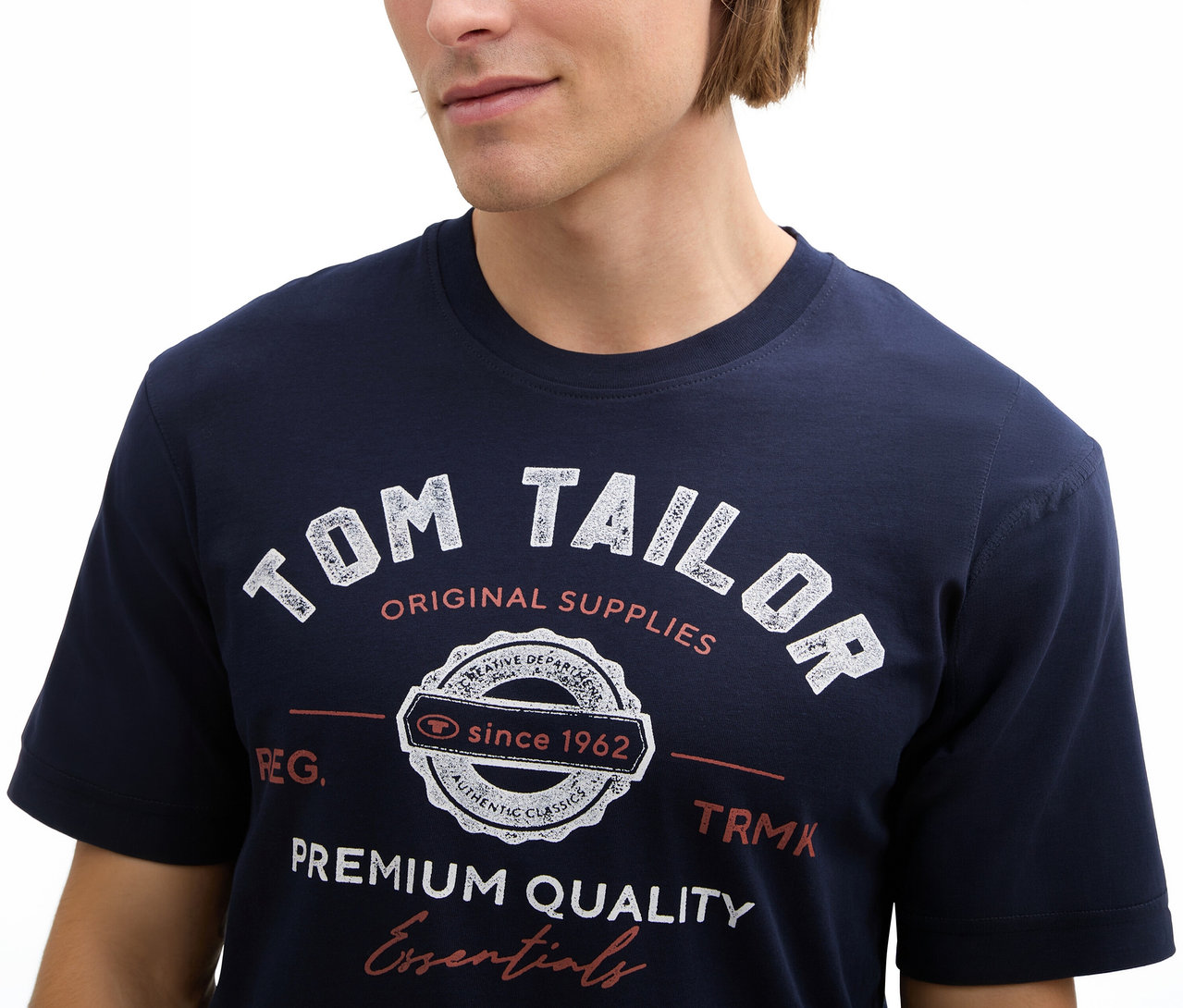 Mann trägt ein Tom Tailor T-Shirt mit Logo, Sky Captain Blue.