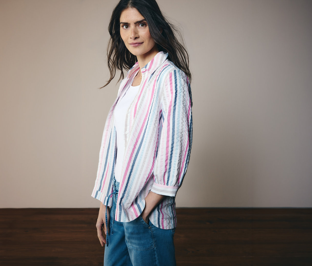 Frau mit geringelter CECIL Hemdbluse mit 3/4 Ärmeln und Jeans. Sie hat eine Hand in der Hosentasche.