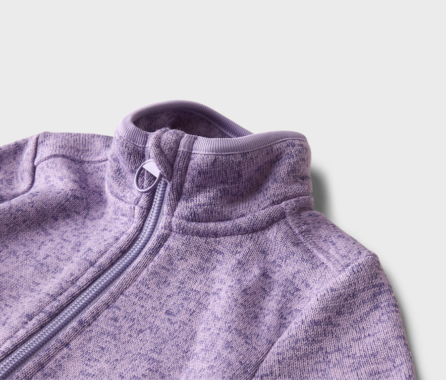 Nahaufnahme einer lila Fleecejacke mit Reißverschluss und hohem Kragen vor einem weißen Hintergrund.