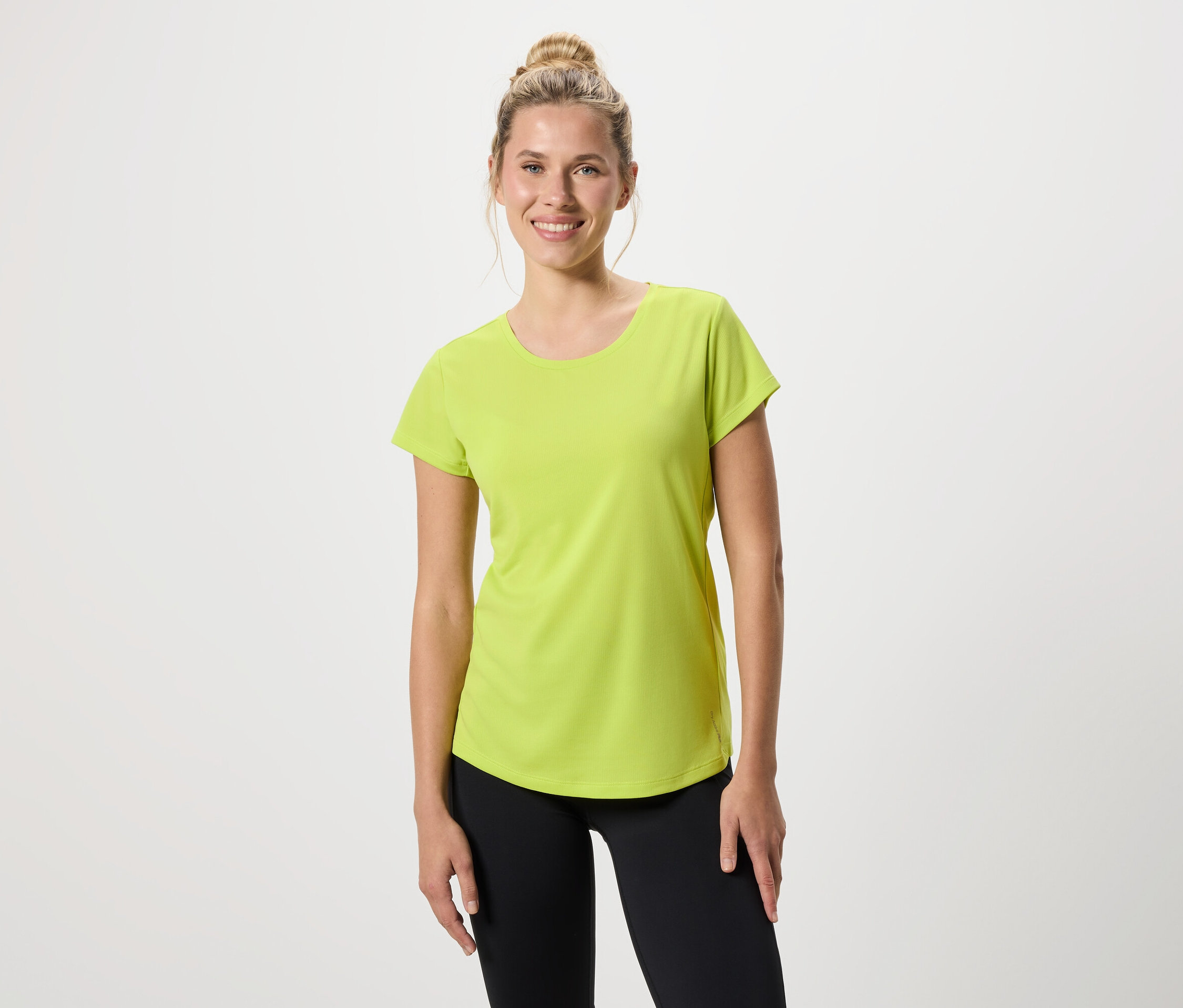 Frau trägt ein hellgrünes T-Shirt und schwarze Leggings.