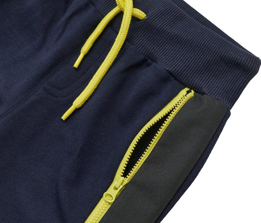 Detailansicht der JAKO-O Sweathose »robust« in Marineblau mit gelbem Kordelzug und Reißverschlussdetail.
