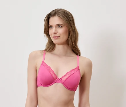 Frau trägt einen pinkfarbenen BH mit Spitze.