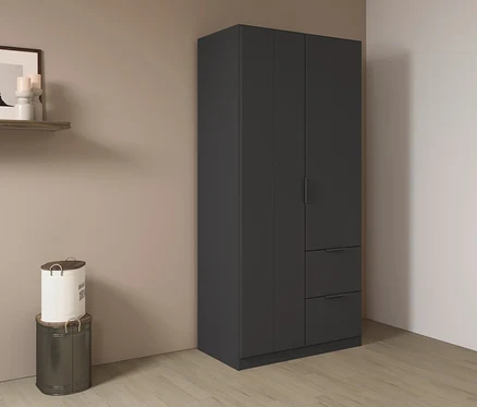 Ein grauer Kleiderschrank mit zwei Schubladen steht in einer Ecke. Links davon stehen zwei übereinander gestapelte Behälter.