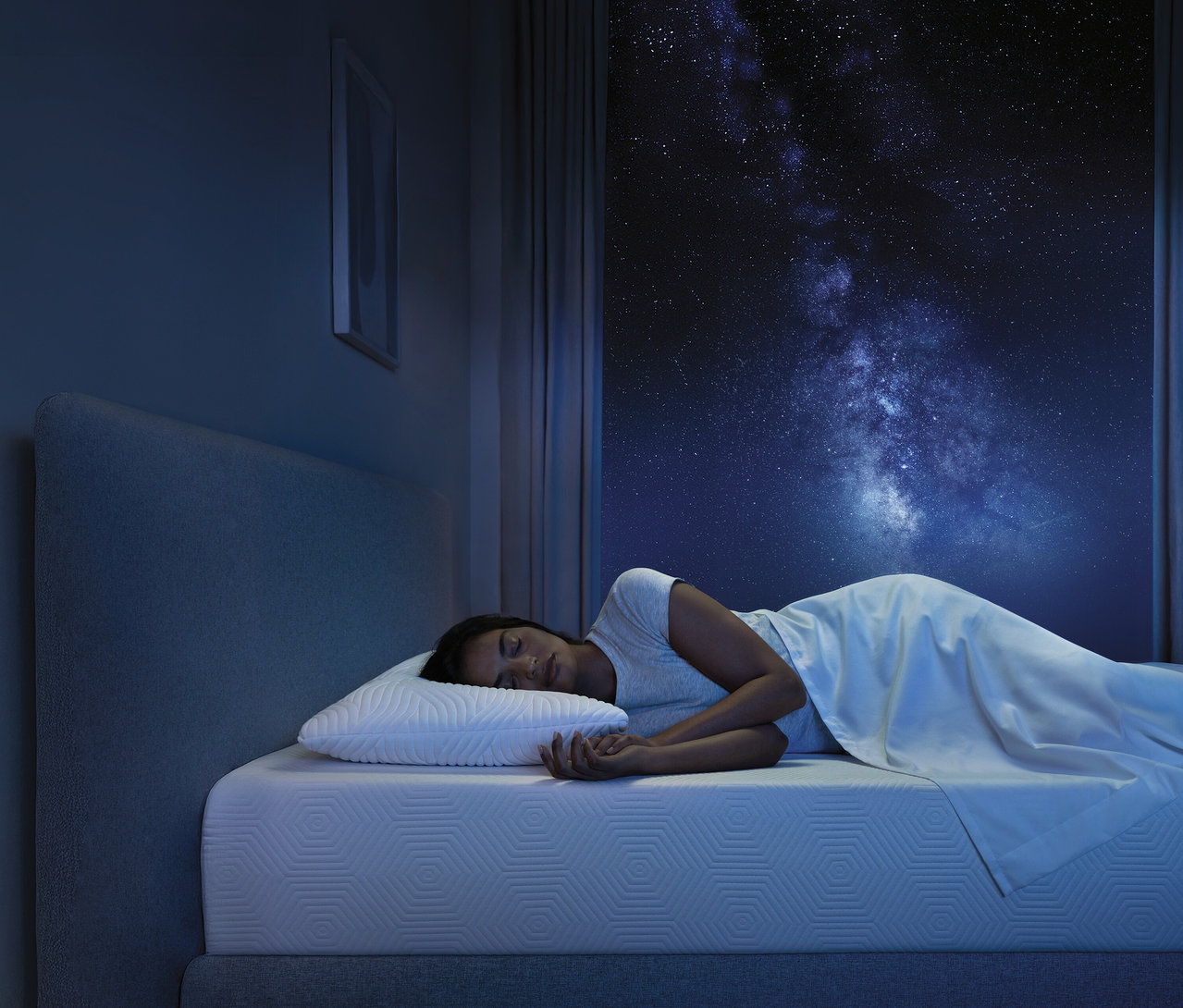 Frau schläft auf TEMPUR Form™ Plus Matratze, medium, 80 x 200 vor Fenster mit Sternenhimmel.