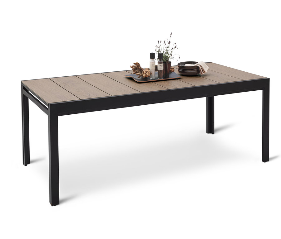 Esstisch mit Holzplatte und schwarzem Metallgestell. Auf dem Tisch stehen Teller, Dekoartikel und Pflanzen.