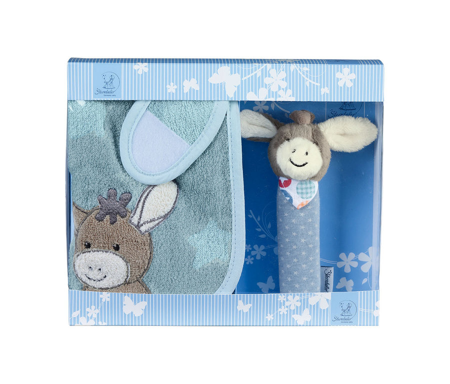 Ein Baby-Geschenkset in einer hellblau-weiß gestreiften Schachtel mit Sichtfenster. Darin befinden sich ein hellblaues Lätzchen mit einer braunen Eselkopf-Stickerei und eine Rassel mit lächelndem Eselkopf und blauem Griff mit weißen Sternen.