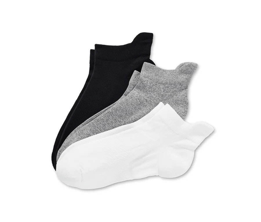 Drei Paar Funktions-Laufsocken in Schwarz, Grau und Weiss liegen übereinander.