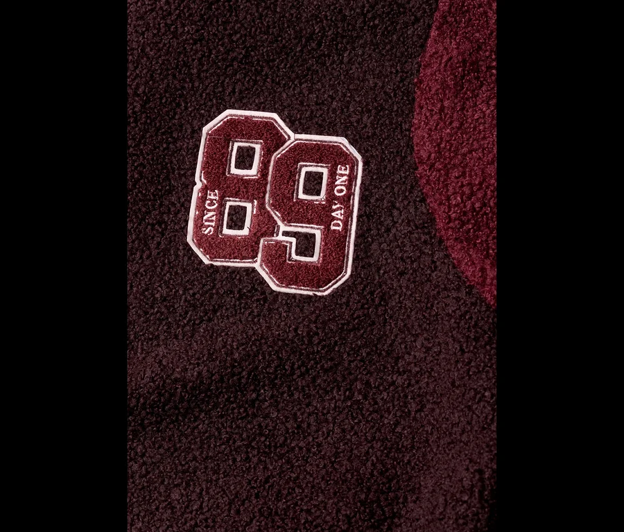 CECIL Blouson aus dunkelbraunem Stoff mit weinrotem '89'-Patch, der 'SINCE' und 'DAY ONE' zeigt.