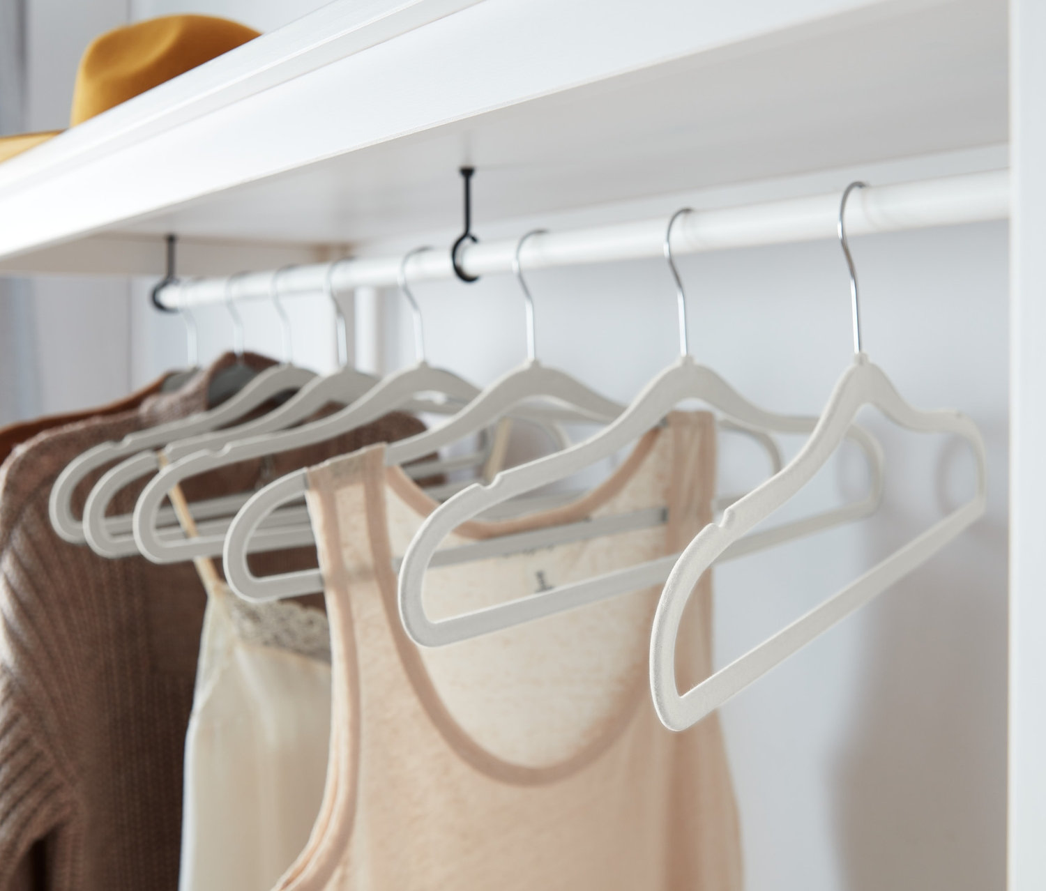 Kleidung hängt an acht grauen, extraschmalen Kleiderbügeln.