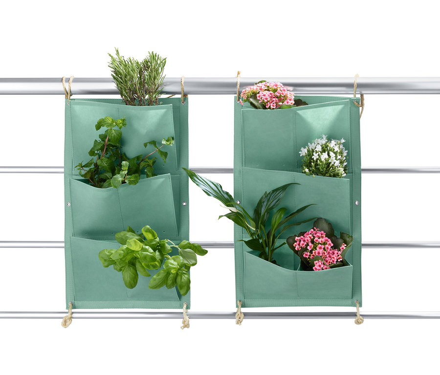 Zwei grüne Pflanztaschen »Vertikalbeet« mit Pflanzen hängen an einem Metallrahmen.