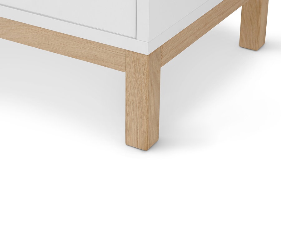 Detailansicht einer »Eklund« Kommode mit Schubladen und Tür, die die Beine des Möbels zeigt.