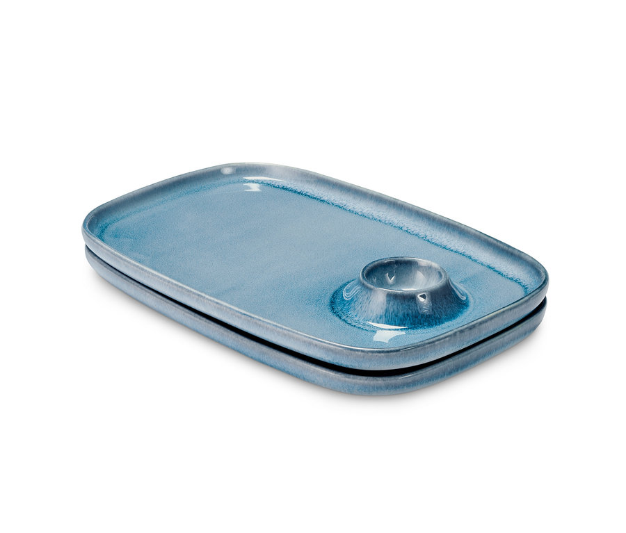 Zwei blaue Frühstücksteller mit Eierhalter.