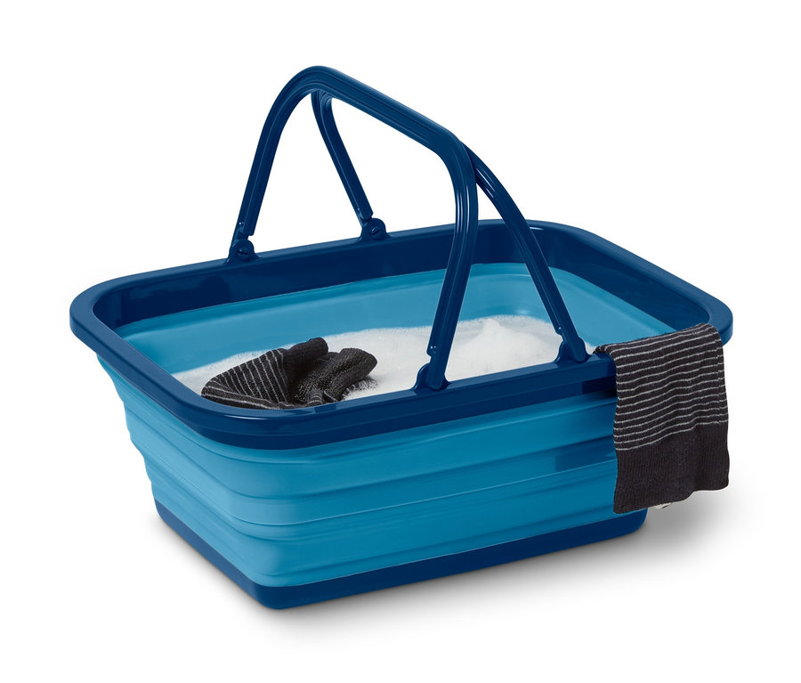 Eine faltbare Spülschüssel mit Wasser, einem Waschlappen und Handschuhen.