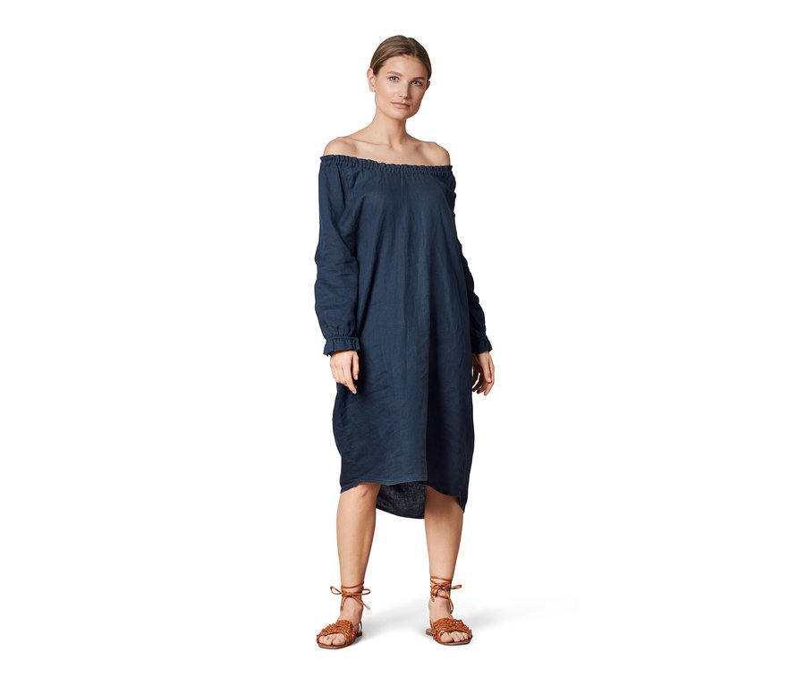 Frau posiert in einem Leinenkleid.