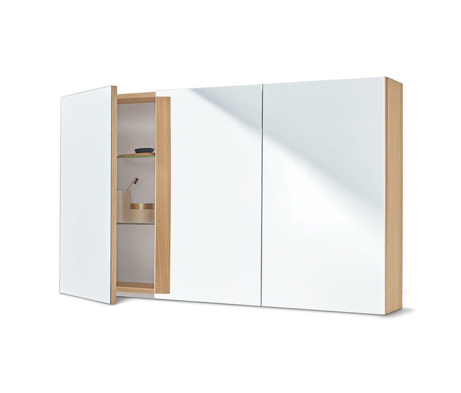 Ein 3-türiger Spiegelschrank, eine Tür ist offen, im Inneren befinden sich eine Haarbürste, eine Zahnbürste und eine Creme.