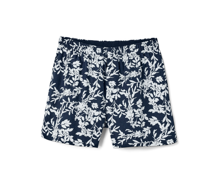 Eine einzelne Web-Boxershorts mit einem weißen Blumenmuster auf dunkelblauem Grund.