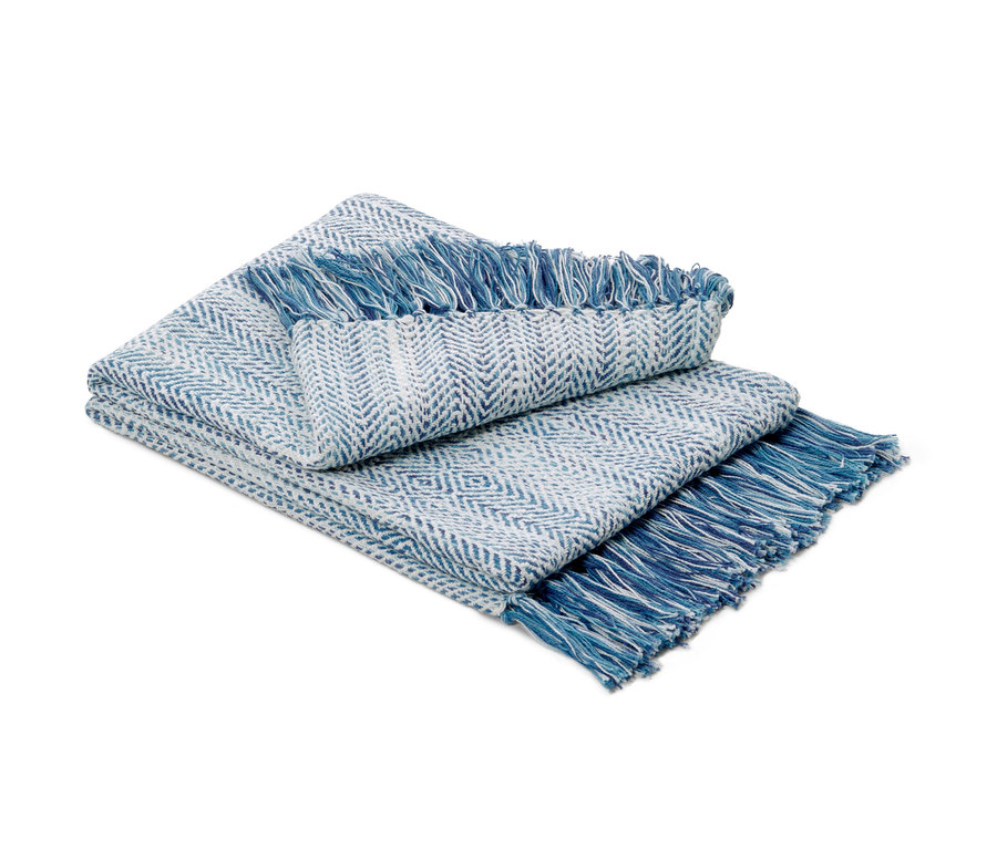 Gefaltete blau-weiße Wohndecke mit Fransen.