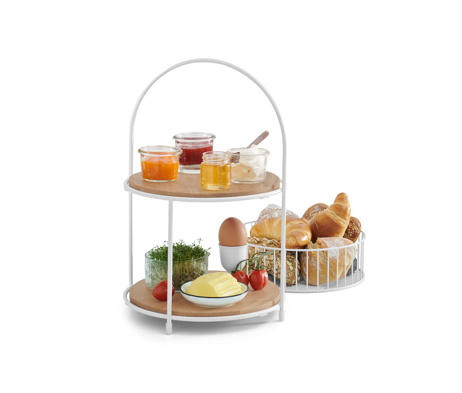 Etagere mit Brotkorb mit Marmelade, Honig, Butter, Ei, Tomaten und Gebäck.