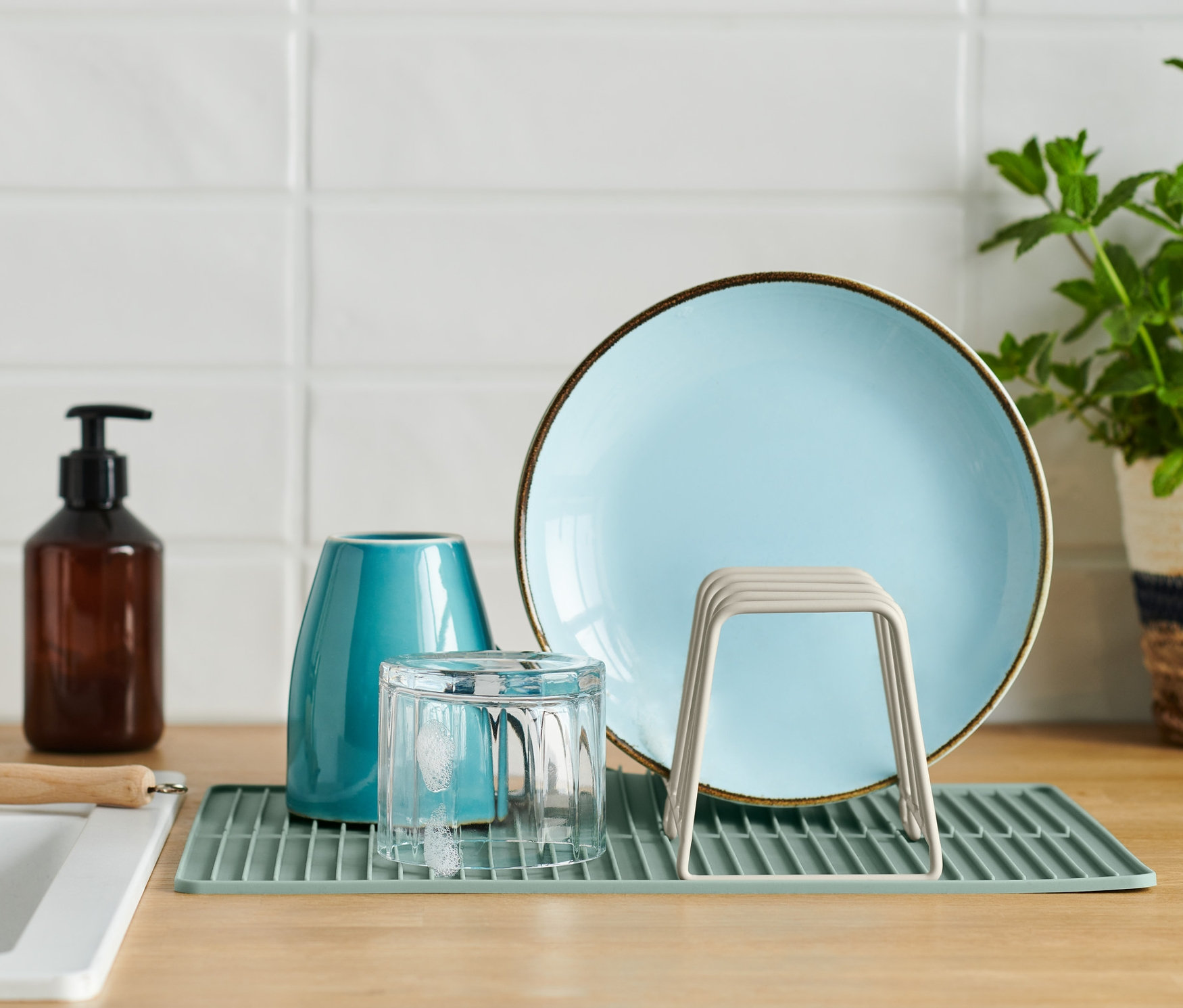Auf der Küchentheke steht ein Abtropfgestell mit einem Teller, einem Glas und einer Vase.