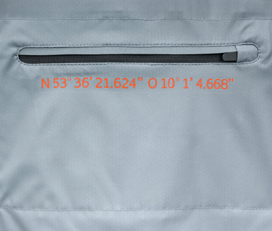 Detailansicht einer grauen Windprotection-Funktionsjacke mit Reißverschlusstasche und orangefarbenem Koordinatenaufdruck.