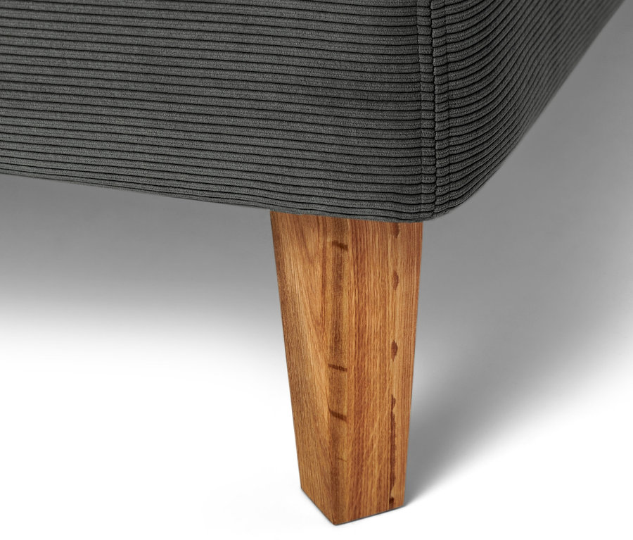 Detailaufnahme eines anthrazitfarbenen Boxspringbetts mit Holzfuß.