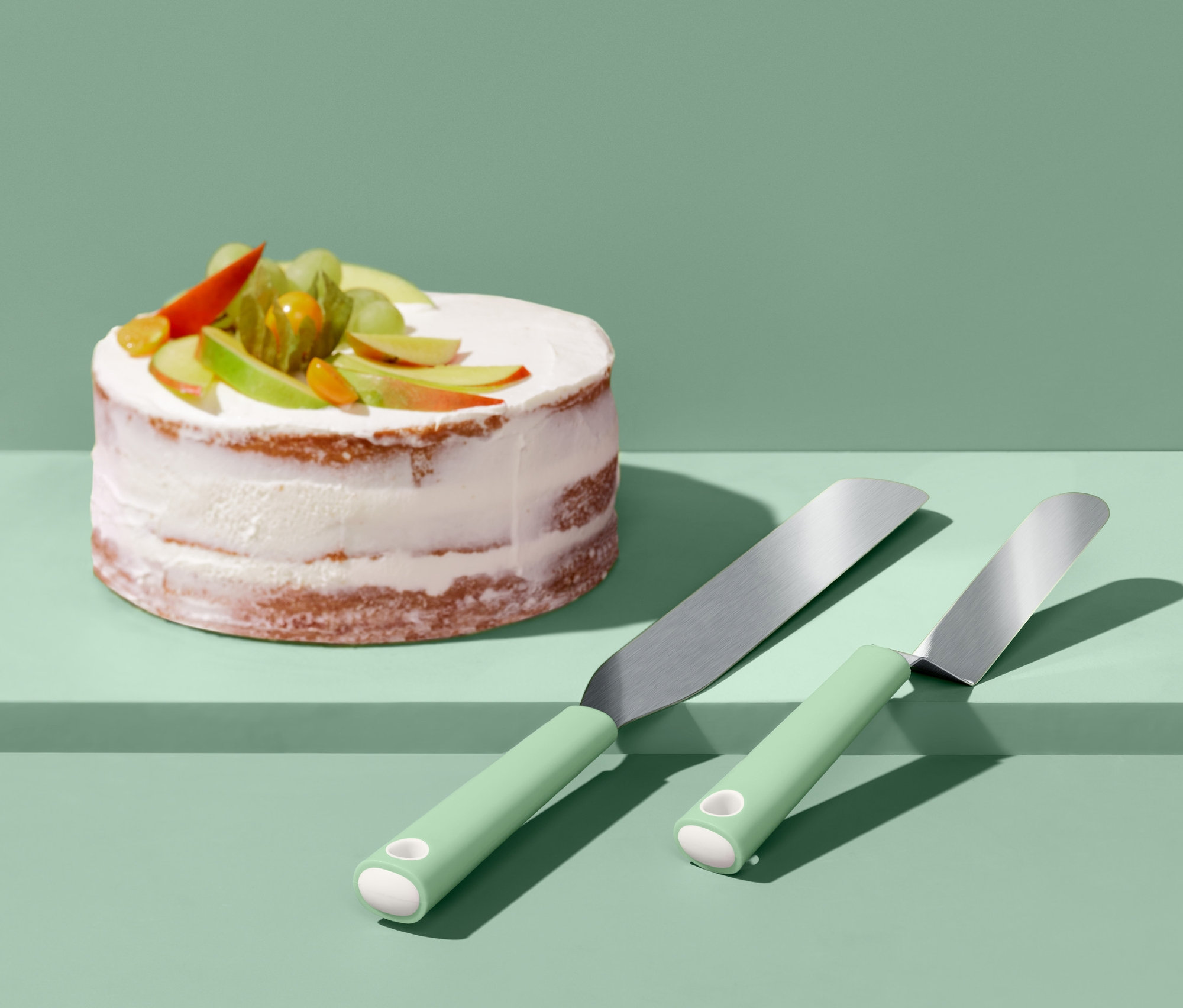 Verzierter Kuchen neben zwei Streichpaletten.