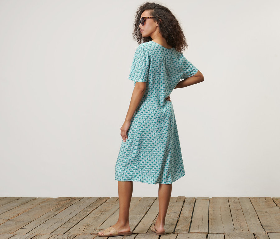 Frau posiert in einem Kleid mit Print.