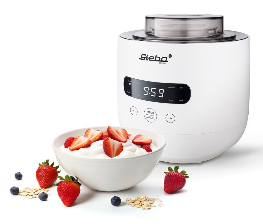 Eine weiße Schale Joghurt mit Erdbeeren und Himbeeren neben einem Steba Joghurt-und-Frischkäsebereiter JM4.