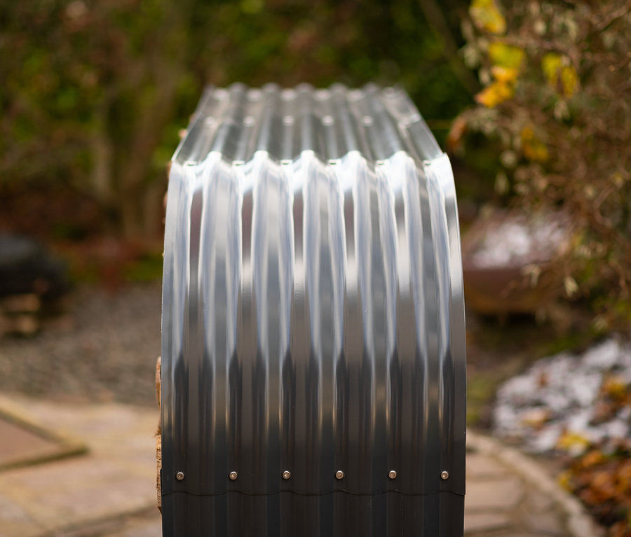 Ein Kaminholzregal aus Metall steht im Freien.