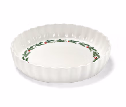 Eine weiße Tortenform mit Weihnachtsmotiv aus Tannenzweigen und roten Beeren.