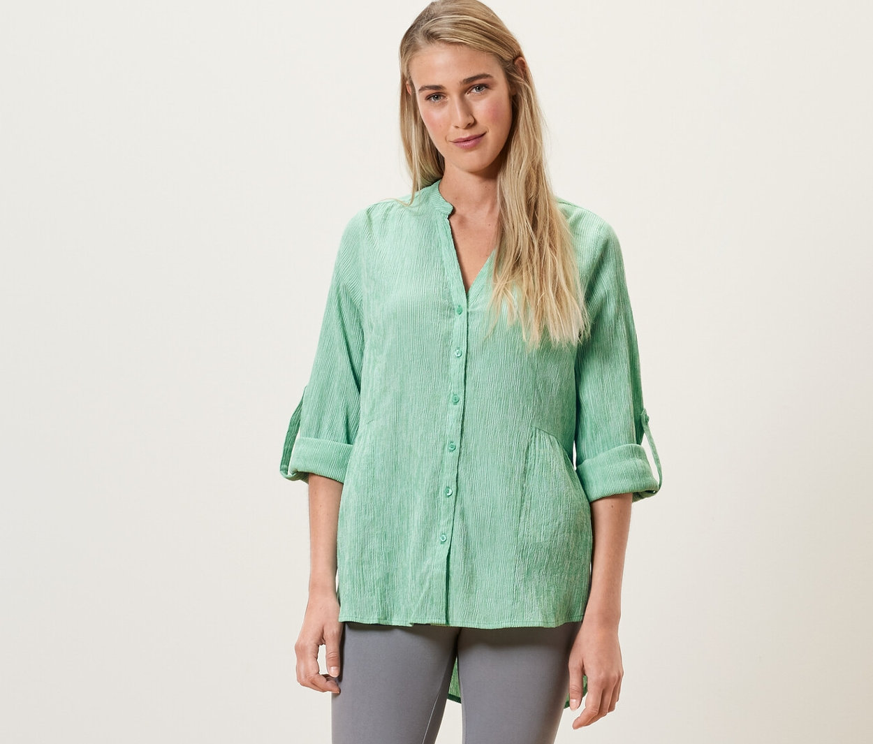 Frau trägt eine grüne, gestreifte Longtunika.