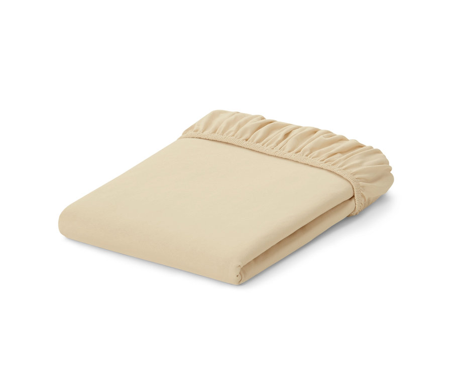 Ein gefaltetes, cremefarbenes Jersey-Spannbettlaken.