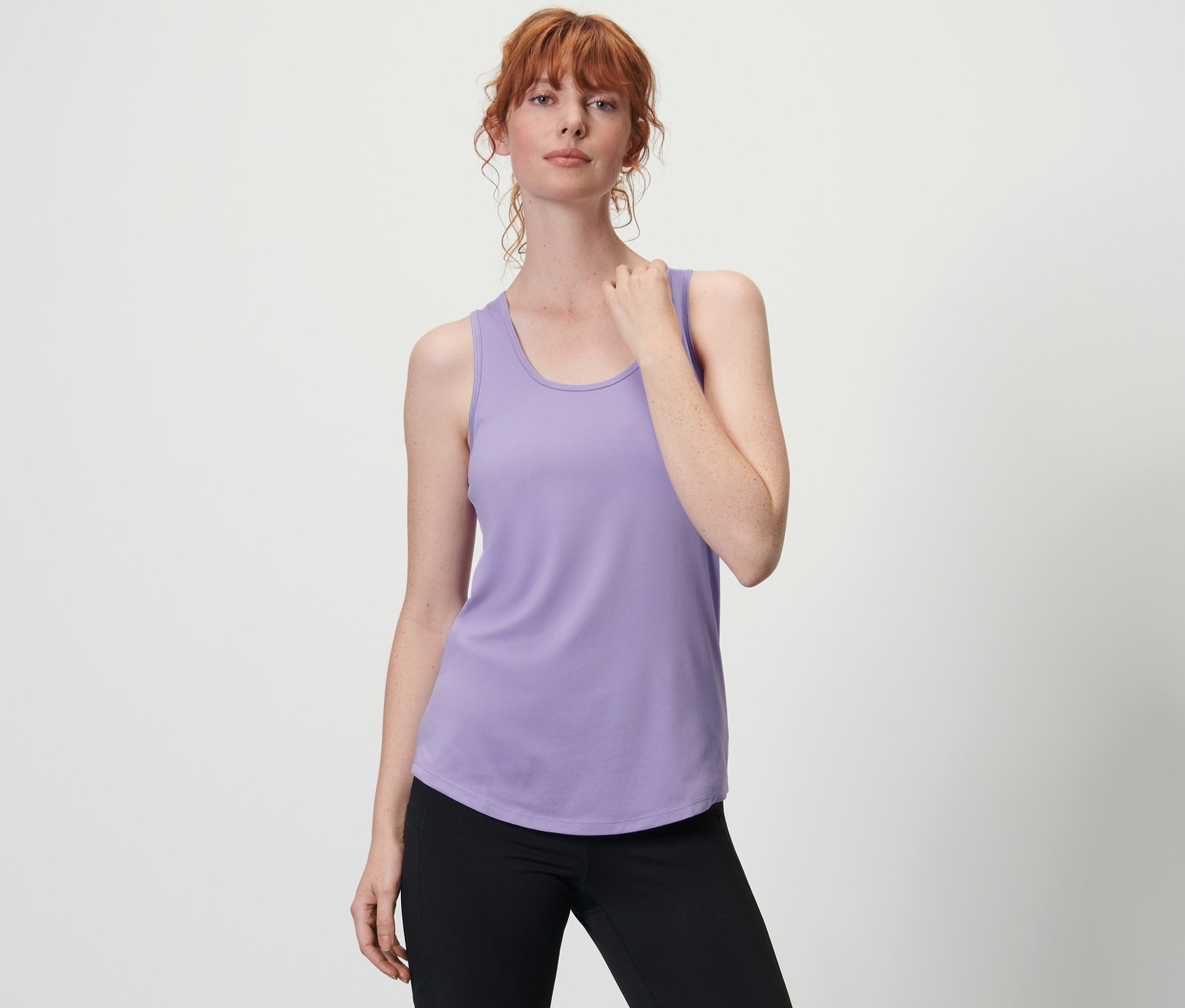 Frau trägt ein lila Funktionstop aus einem 2er Set und eine schwarze Dreiviertelhose.