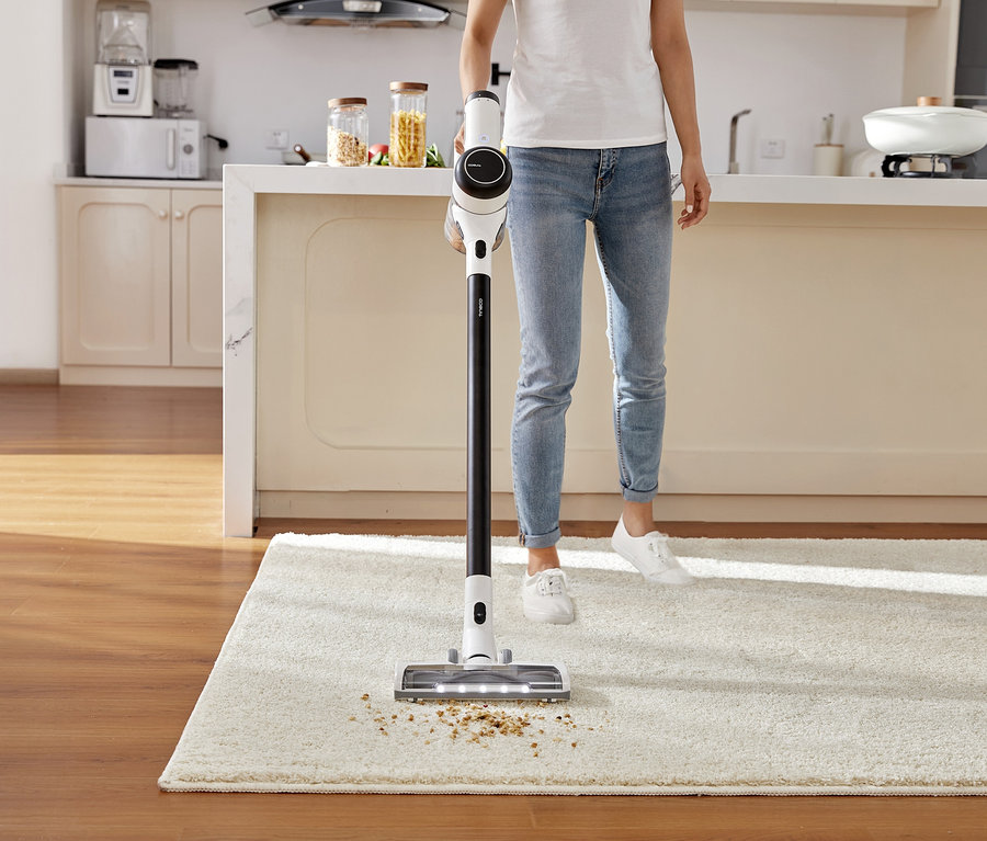 Frau saugt Teppich mit Tineco Pure One x Essentials Akkusauger.
