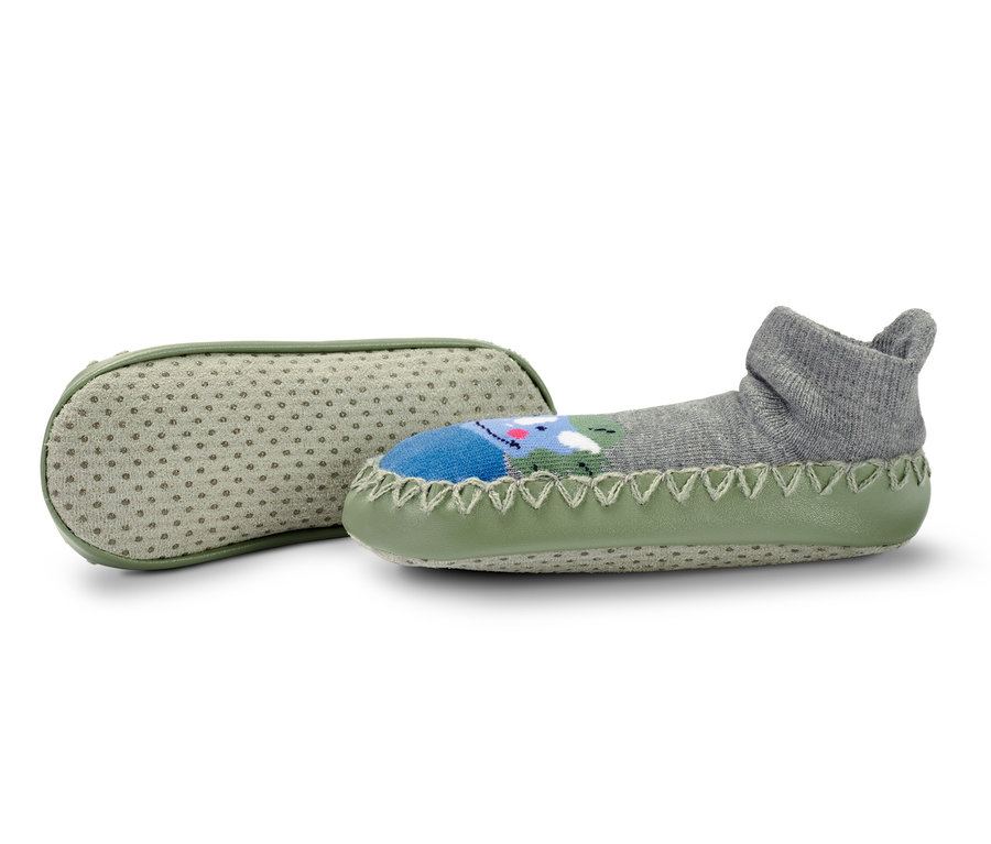 Zwei Paar Kinder-Hausschuh-Socken: ein graues Paar mit Dinosaurier-Motiv und ein Paar mit hellgrüner Sohle.