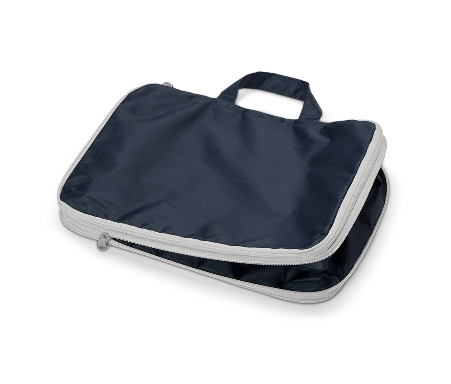 Eine marineblaue Kompressionstasche mit silbernem Reißverschluss und Griff.