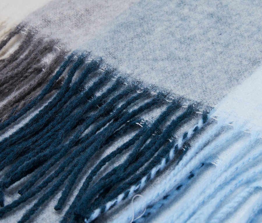 Detailansicht eines gestreiften Webschals in Blau-, Grau- und Weißtönen.