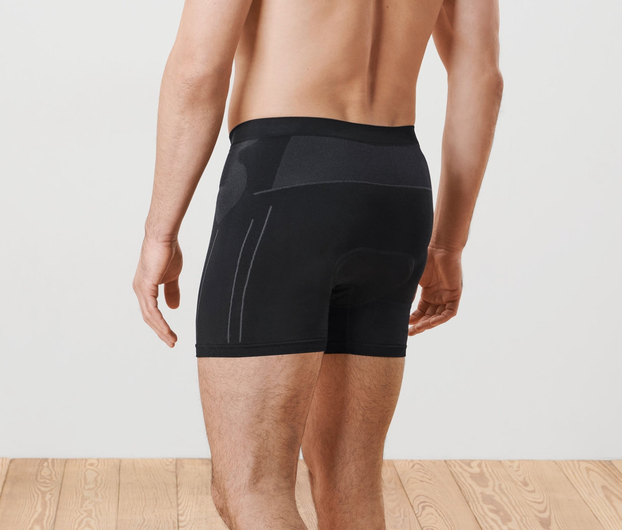 Mann posiert mit dem Rücken zur Kamera und trägt eine Radunterhose.