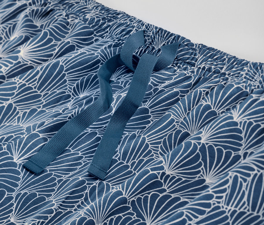 Detailaufnahme einer blauen Pyjamahose mit weißem Muster und Kordelzug.